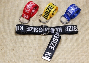 Detail of colorful canvas belts with double D-ring buckles and white Kingsize lettering