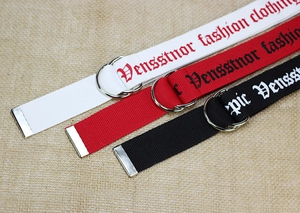 Dettaglio di cinture in tela di nylon bianco, rosso e nero con fibbia a doppio anello a D