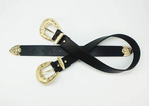 Detail of vintage carved gold buckles and tips on classic black leather belts