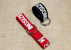 Detalle de cinturones de lona rojos y negros con letras KINGSIZE y hebillas de doble anillo en D