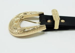 Detail of western vintage belt showing gold baroque carved buckle and black leather strap