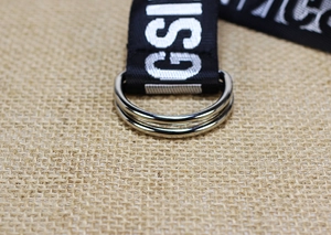 Macro shot of nylon canvas belt featuring double metal D-rings and white printed letters