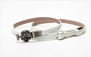 Detail of white patent leather thin belt with vintage silver camellia floral buckle