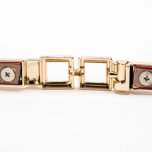 Glossy candy-colored patent leather belt with a golden metallic interlocking buckle