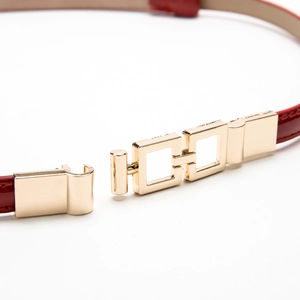Red patent leather skinny belt for women with a gold geometric metal buckle detail