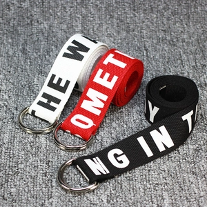 Three canvas belts in white red and black with D-ring metal buckles and printed text