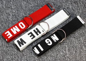 Close-up of durable canvas belts in red, white, and black with silver double D-ring buckles