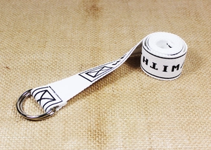 Close-up of white canvas belt with black WITH text and silver double D-ring metal buckle