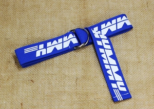 Detail of blue canvas belt with double D-ring buckle and white MMY lettering print