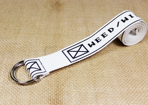 Detail of white nylon belt with silver double D-ring buckle and black pixel font pattern