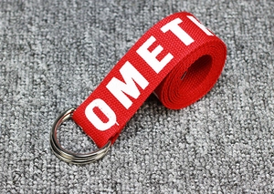 Detail of red nylon canvas belt with silver double D-ring buckle and white OMETI print