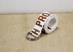 Détail d'une ceinture en toile blanche avec lettrage marron et boucle double D en métal