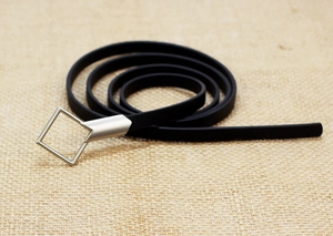 Detail of slim black leather belt featuring a silver square hollow metal buckle