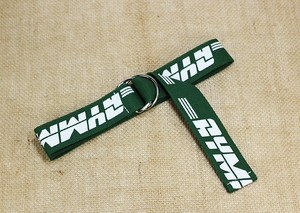 Detail view of the dark green nylon belt with silver double D-ring buckle and white RYM text