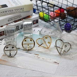 Dettaglio di cinture in PVC trasparente con fibbie metalliche a cuore e rotonde dorate