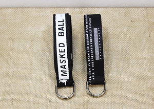 Détail de sangles en nylon noir avec texte sérigraphié blanc et anneaux en D argentés