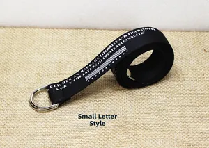Détail d'une ceinture en toile de nylon noire avec boucle en D argentée et imprimé texte