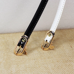 Glossy patent leather skinny belts in black and white with gold heart charms for jeans