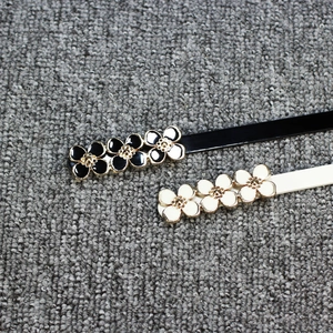 Lot de deux fines ceintures en cuir verni avec boucles fleuries élégantes noir et crème