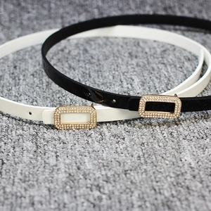 Women's slim patent leather belts in black and white with rhinestone encrusted gold buckles