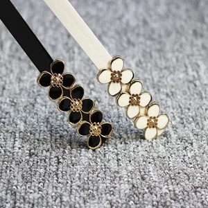 Lot de barrettes à fleurs noir et blanc avec centre doré sur fond en maille douce