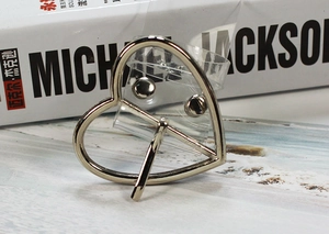 Dettaglio della fibbia in metallo a forma di cuore su cintura in PVC trasparente