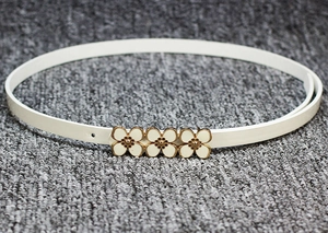 Vue détaillée d'une ceinture fine en cuir verni blanc avec boucle florale dorée