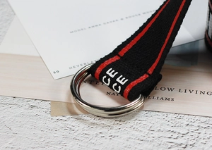 Gros plan sur la ceinture en toile de nylon noire avec rayures rouges et boucle en métal