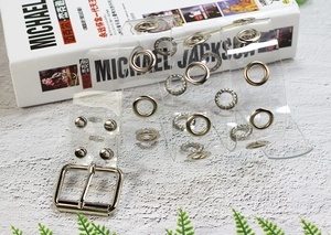 Detail of transparent PVC belt featuring silver metal eyelets and polished buckle