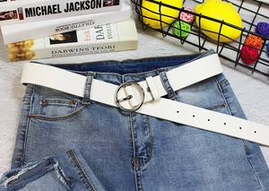 Ceinture en cuir PU blanc avec boucle ronde argentée portée sur un jean en denim