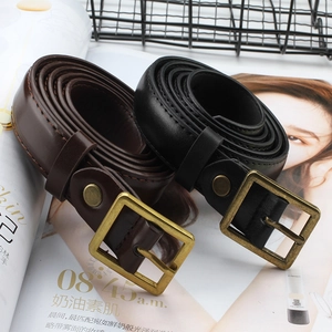 Retro unisex faux leather belt with a vintage brass buckle shown on a fashion magazine