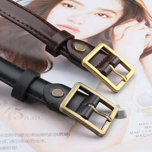 Detail view of retro bronze buckles and double rivets on black and brown leather belts