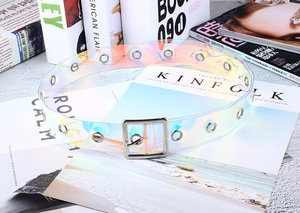 Détail d'une ceinture en PVC holographique avec boucle argentée et œillets en métal