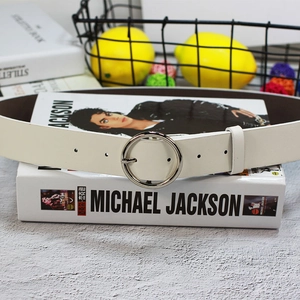 Gros plan d'une ceinture en cuir blanc avec boucle ronde argentée sur fond décoratif