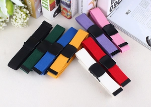 Detailed close-up of colorful nylon canvas belts with matte black buckles in a flat lay view