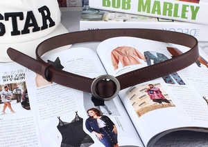 Detailed view of dark brown leather belt with round matte metal buckle and stitching