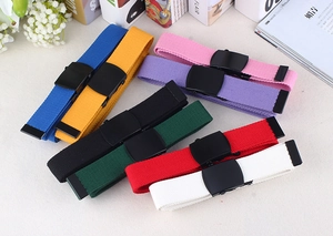 Detailed overhead view of multiple colorful nylon canvas belts with matte black buckles