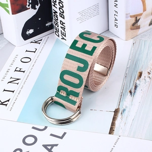 Détail de la ceinture en toile beige avec texte PROJECT vert et boucle en métal double anneau D