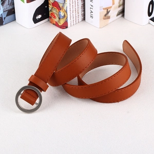 Detail of caramel brown faux leather belt with round silver buckle and stitching