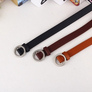 Detailed view of narrow belts in black, dark brown, and tan with silver round buckles