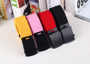 Close-up of colorful canvas belts in yellow, pink, red, and black with matte black buckles