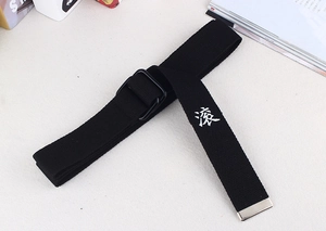 Détail de la ceinture en toile noire avec boucle en D et caractère chinois brodé en blanc