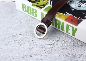 Detail of dark brown leather belt with round silver metal buckle and fine stitching