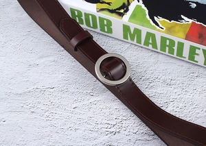 Detailed view of dark brown faux leather belt with round silver buckle and stitching