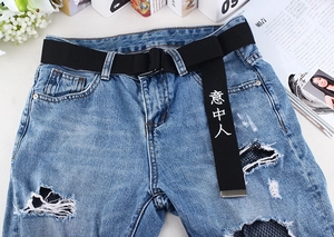 Détail d'un jean bleu clair vieilli avec une ceinture noire à lettrage chinois