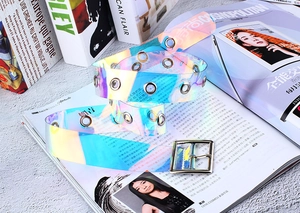 Détail d'une ceinture laser en PVC holographique avec boucle carrée et œillets en métal