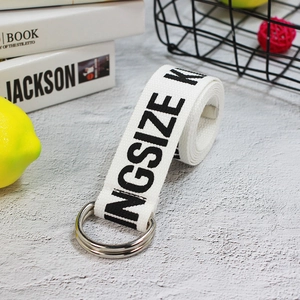 Close-up of white canvas belt with KINGSIZE print and silver double D-ring buckle