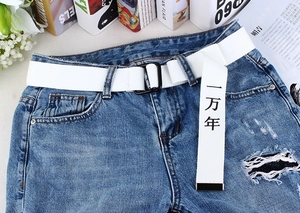 Détail de la ceinture en toile blanche avec boucle double D et imprimé de caractères chinois