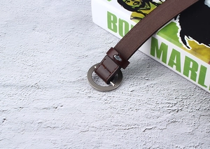 Detail of dark brown leather belt with silver round buckle and stitching accents