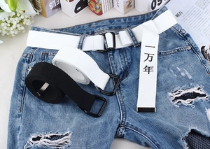 Détail de la ceinture en toile blanche avec texte 10000 ans et boucle en D noire